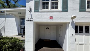 A white building with a number 707 sign, a reserved parking sign, and a covered entrance. - Lander & Mt Rose Duo | Near Midtown & Downtown (Reno)