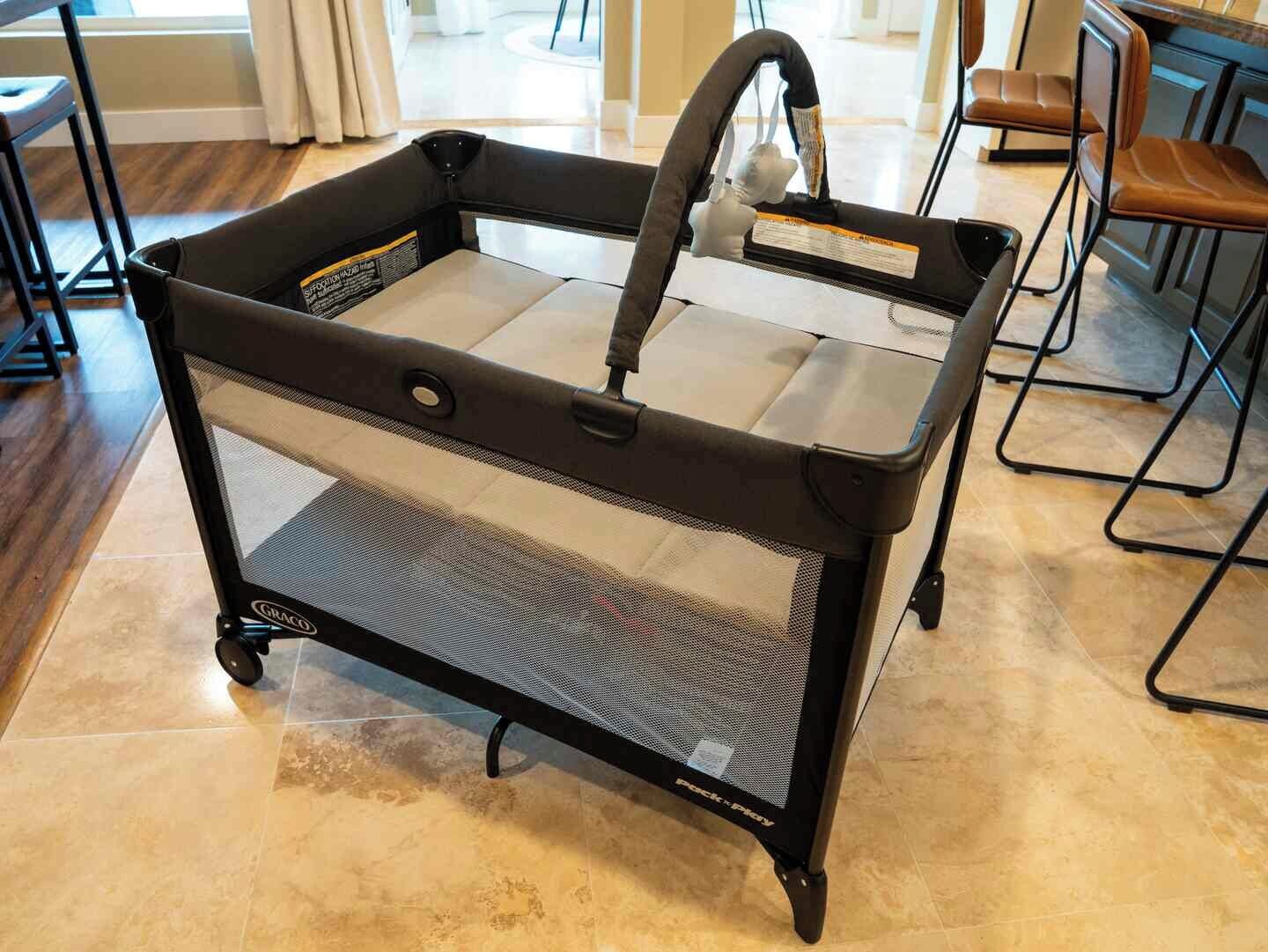 A portable baby stroller with a mesh seat and storage basket.