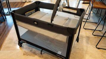 A portable baby stroller with a mesh seat and storage basket.