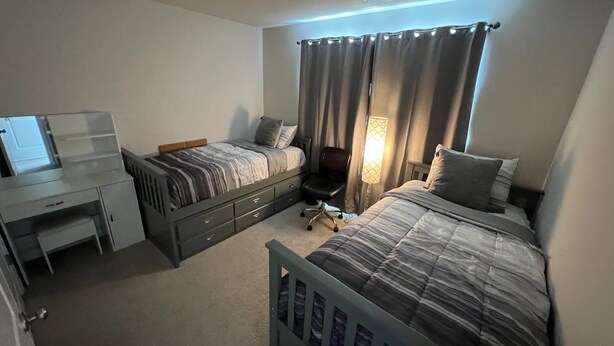 A bedroom with two beds, a desk, and a chair. - Beautiful Townhouse 4 bedroom 3  bathroom in Fogelsville PA (Fogelsville)