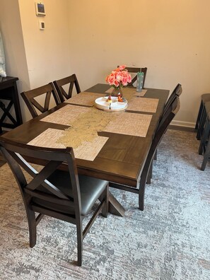 A dining table with a placemat, a vase with flowers, and a plate with a dessert. - Beautiful Townhouse 4 bedroom 3  bathroom in Fogelsville PA (Fogelsville)
