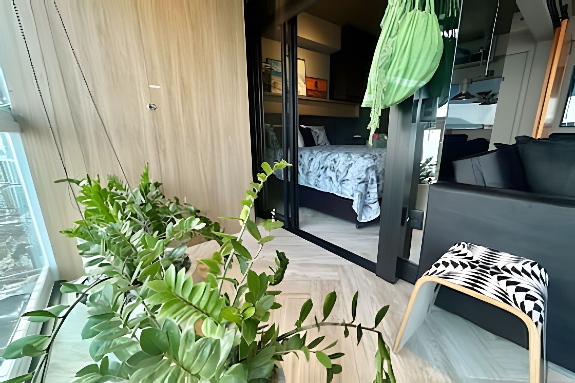 A modern hotel room with a bed, a small seating area, and a large window.