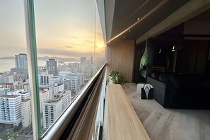 A modern interior with a large window overlooking a cityscape at sunset. - SHB Alto padrão com Vista Panorâmica (Santos)