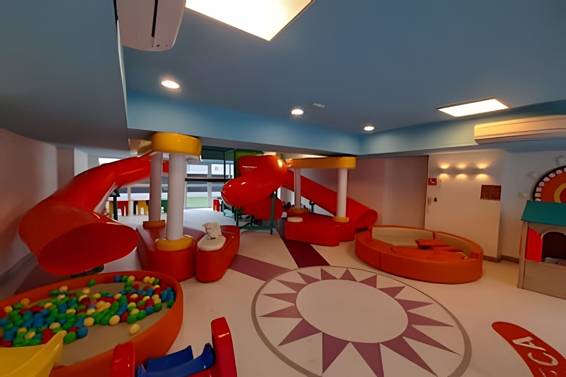 Un área de juegos infantiles con toboganes y una piscina de pelotas.