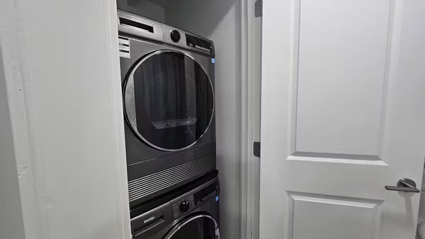 Un cuarto de lavandería con lavadoras y secadoras apiladas.