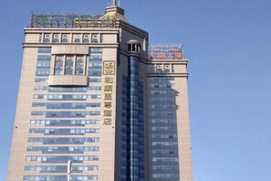 A multi-story hotel with a prominent vertical sign on the facade. - Yitel Premium (Shanghai)