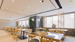A spacious dining area with multiple tables and chairs, large windows, and decorative plants. - Yitel Premium (Shanghai)
