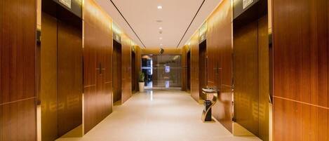 A corridor with wooden doors and a central light fixture.