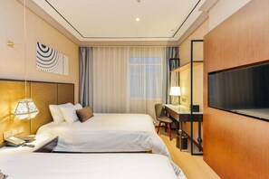 Une chambre d’hôtel avec deux lits, un bureau, une chaise, une télévision et une fenêtre avec des rideaux.
