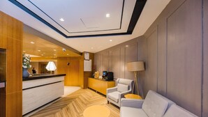 A hotel lobby with a reception desk, seating area, and a coffee machine. - Yitel Premium (Shanghai)