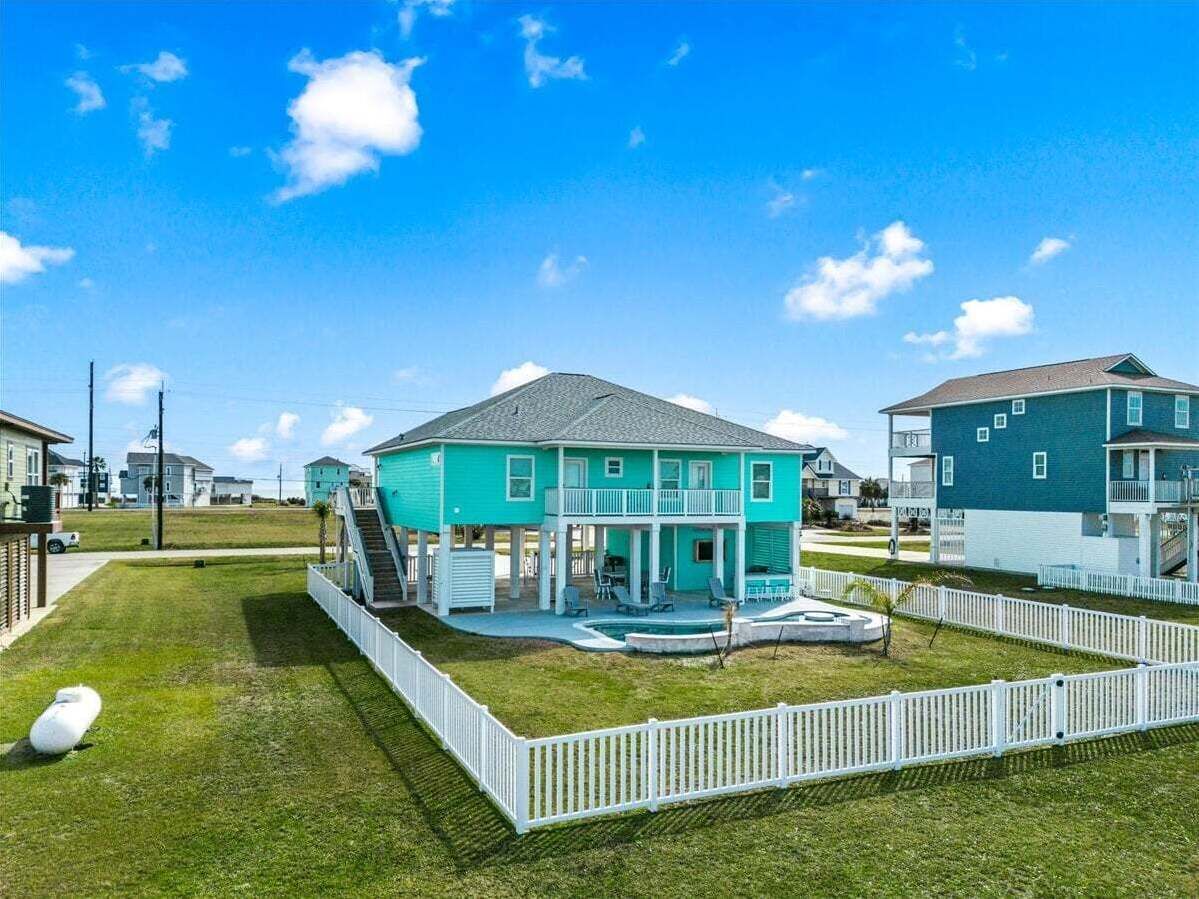 A two-story house with a covered patio and a swimming pool.
