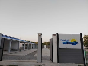 Een gebouw met een bord waarop 'Punta Azul' staat en een logo met een zon en golven.