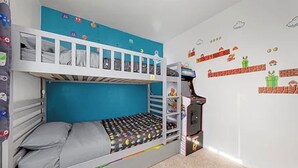A bunk bed room with a blue wall, a Mario-themed wall decal, and a Nintendo 64 console. - North Park 3BR Furnished Rental—31-Night Minimum (San Diego)