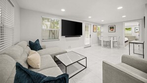 Uma sala de estar moderna com sofá, mesa de centro e televisão.