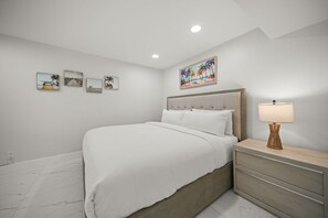 Ein Schlafzimmer mit einem Bett, einem Nachttisch, einer Lampe und Wandbildern.