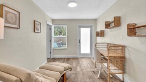 A room with a wooden floor, a dining table with chairs, a bench, and framed artwork on the walls. - 2240 Managed by Brampton Park (Pompano Beach)