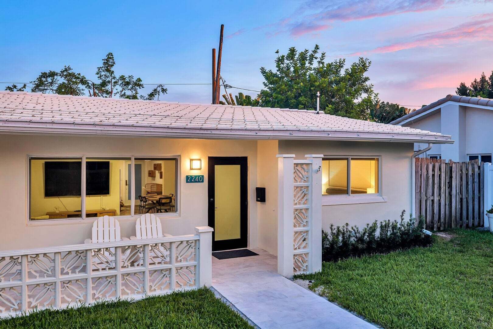 Ein eingeschossiges Haus mit Veranda und Essbereich, die Hausnummer '2240' ist auf der Tür sichtbar.