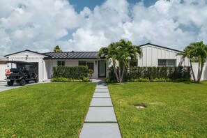A modern two-story house with a garage, a paved driveway, and a well-maintained lawn. - 15 Managed by Brampton Park (Delray Beach)