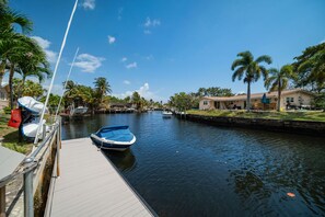 A marina with a dock, a boat, and houses along the water. - 1750 Managed by Brampton Park (Pompano Beach)