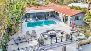 A modern house with a swimming pool, outdoor seating, and a red-tiled roof. - 1750 Managed by Brampton Park (Pompano Beach)