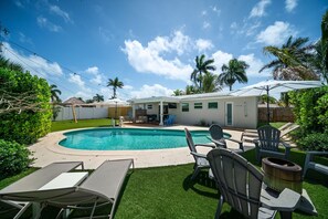 A backyard with a swimming pool, outdoor furniture, and a covered patio area. - 1005 Managed by Brampton Park (Deerfield Beach)