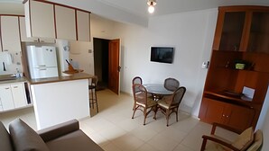 A compact living space with a kitchenette, dining area, and seating. - SHB Lazer completo no melhor do Guarujá (Guarujá)