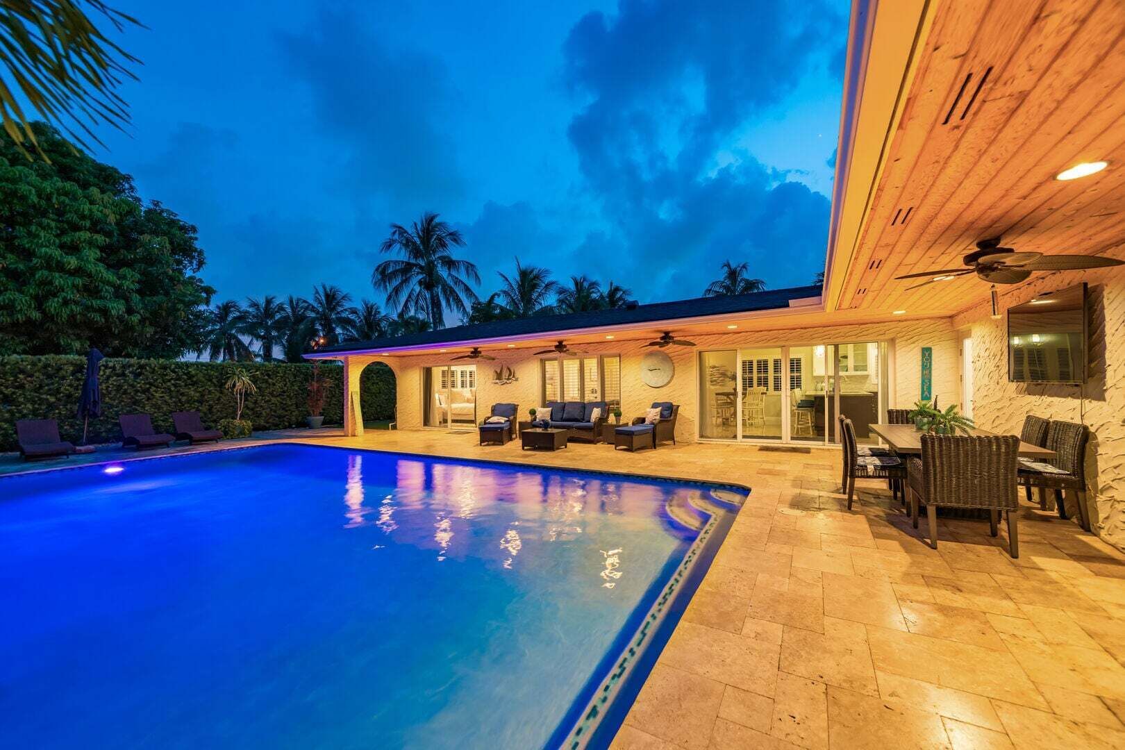 A swimming pool with lounge chairs and a covered patio area.