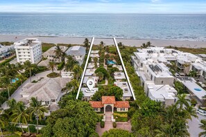 An aerial view of a coastal residential area with a beach, palm trees, and a mix of modern and traditional architecture. - 1855 Managed by Brampton Park (Delray Beach)
