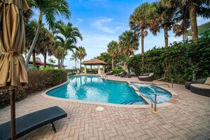 A swimming pool with lounge chairs and a gazebo, surrounded by palm trees and greenery. - 1855 Managed by Brampton Park (Delray Beach)