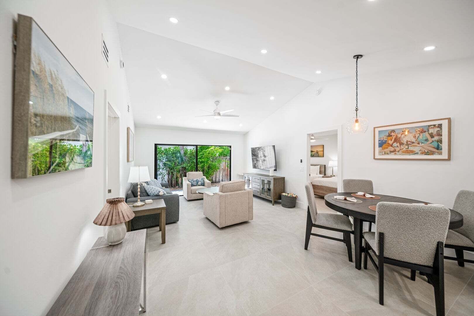 A spacious living area with a dining table, sofas, and a TV.