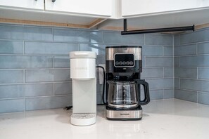 Eine Kaffeemaschine mit Keurig-Kapselspender und einem Shard-Kaffeekrug auf einer Küchenarbeitsplatte.