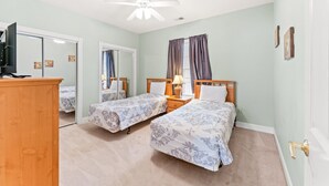 A bedroom with two beds, a ceiling fan, a TV, and a wardrobe. - Golf Villa Near Beach at Myrtlewood | Magnolia Pointe Luster Leaf 4890-304 (Myrtle Beach)