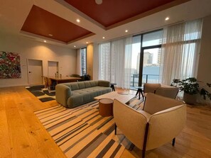 A modern living room with a sofa, armchairs, a coffee table, and a dining area with a table and chairs. - Entire apartment in Miami – NEW (Miami)