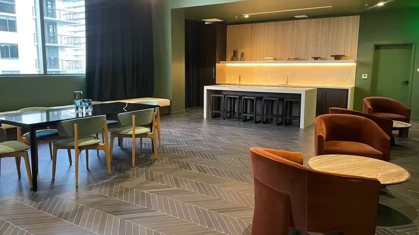 Eine moderne Hotelhalle mit Bar, Sitzgelegenheiten und einem gemusterten Boden.