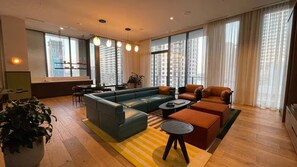 A modern living room with a sectional sofa, a coffee table, and a dining area. - Entire apartment in Miami – NEW (Miami)