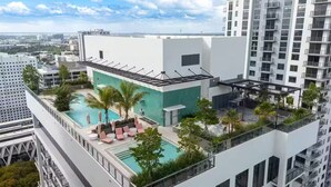 A rooftop pool area with lounge chairs and a view of the cityscape. - Entire apartment in Miami – NEW (Miami)