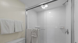 A bathroom with a glass-enclosed shower, a toilet, and two towels hanging on the wall. - Beachfront 3BR/3BA condo with Gulf views in South Padre Island. (South Padre Island)