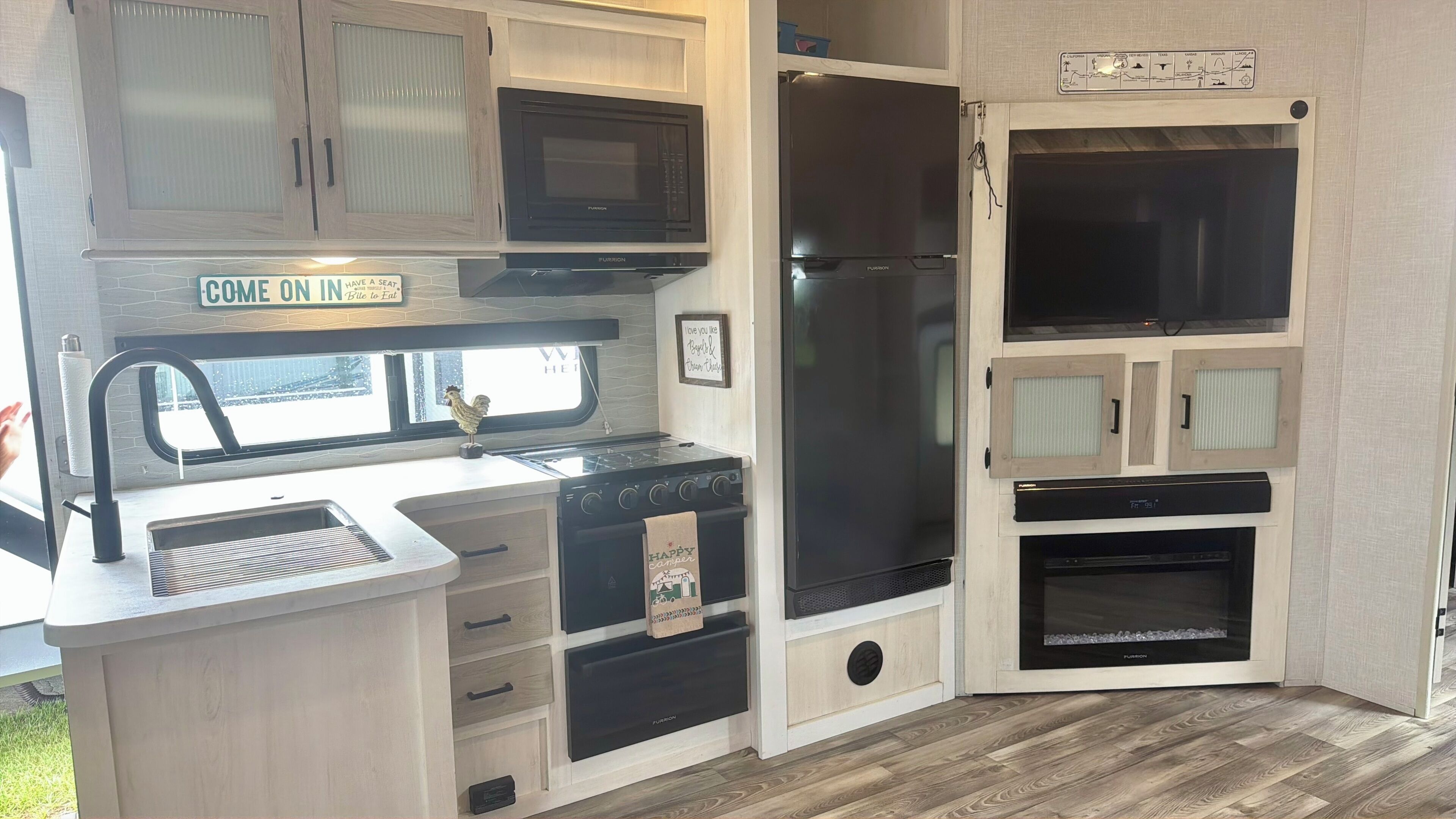 A compact kitchen with a built-in stove, a refrigerator, and a microwave.
