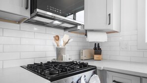 A modern kitchen with a gas stove, a toaster, and a knife block. - Thors Cottage at Hidden Gem Farm-Sleeps 5 (Spring Hill)
