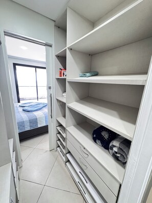 Una camera d'albergo con un letto, un armadio e vista all'esterno.