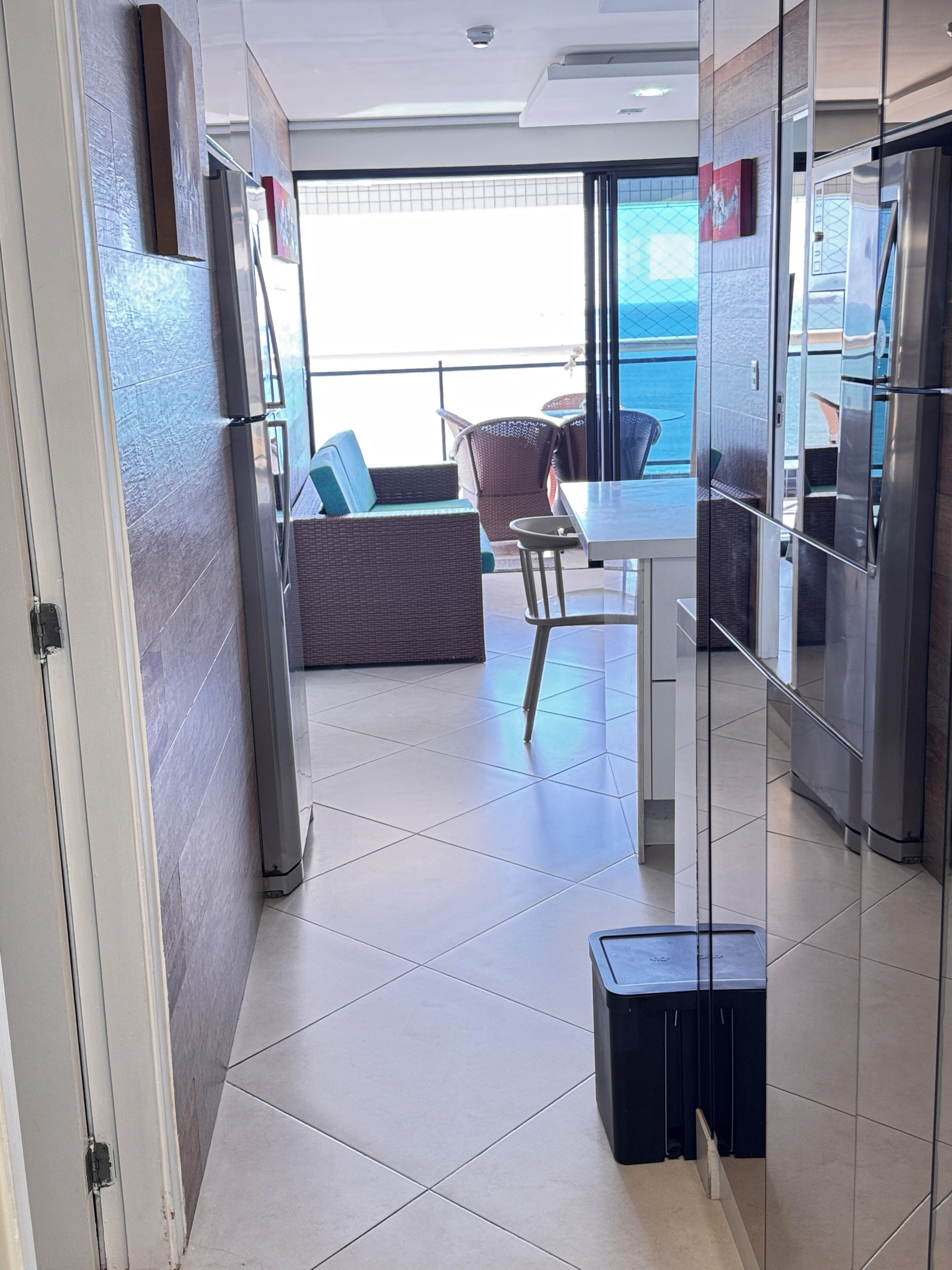 Una cocina moderna con zona de comedor, un refrigerador y vista al mar.