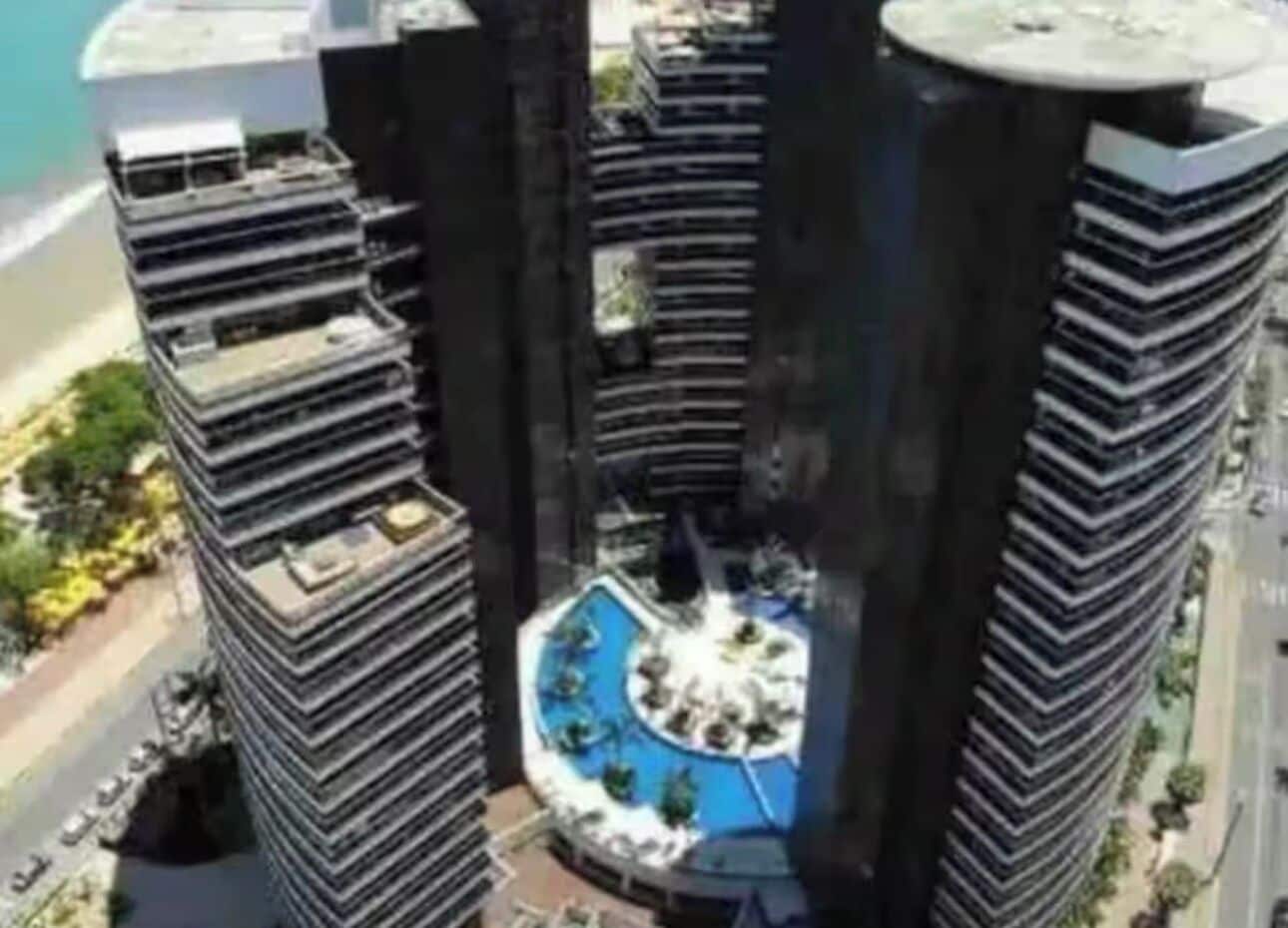 A high-rise building with a circular rooftop pool surrounded by terraces.