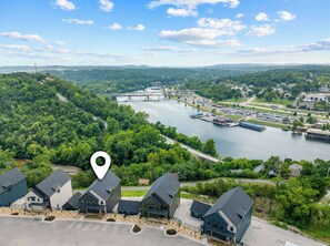 A residential area with houses, a river, and a bridge. - TaneyComo Wake & Lake (Branson)