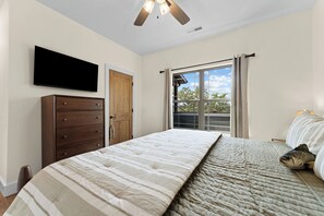 A bedroom with a bed, a dresser, a television, and a window with curtains. - Not So Crappie Cabin - 3BR/3BA, Private Hot Tub, Resort Pools & Lazy River (Hollister)