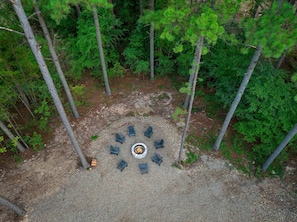 An aerial view of a forested area with a circular arrangement of chairs around a central fire pit. - The Gather House | Private Pool • Sauna • Game Room • UTV Trail Access • Sleeps 26 (Broken Bow)