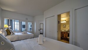Een hotelkamer met twee bedden, een badkamer en een kitchenette.