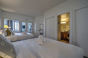 Ein Hotelzimmer mit zwei Betten, einem Badezimmer und einer Küchenzeile.