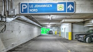 Een parkeergarage met pijlen, betonnen muren en een auto aan de rechterkant.