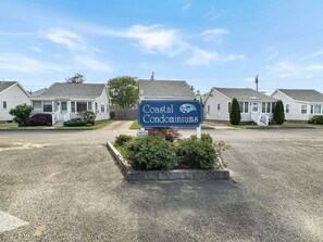 Skilt for Coastal Condominiums med et klart overblik over ejendommen.