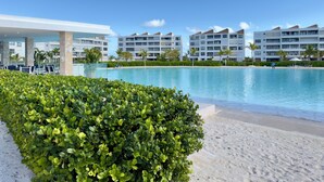 Un resort con piscina, palme e edifici moderni.